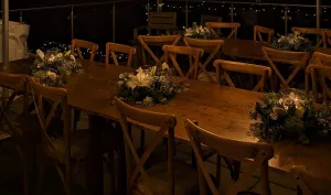Rustic tables and oak crossbacks with lovely flower and candles as centerpieces