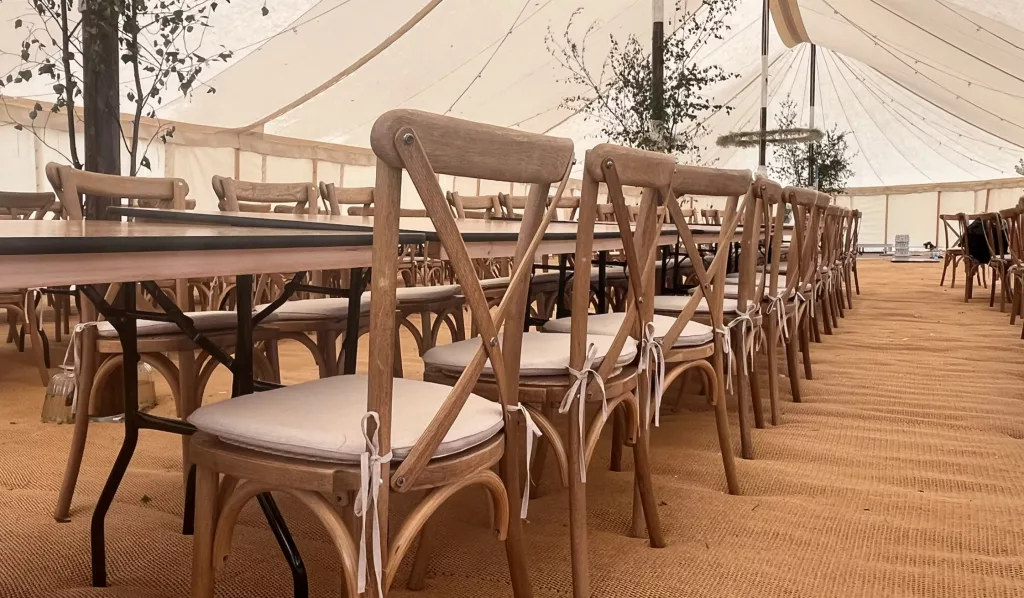 Oak crossback with a beige tie on seat pad in a marquee wedding setup