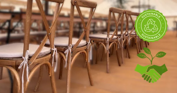 A close up of oak crossback chairs in a rustic wedding with a suatainability patch on one side - The cover for a guide to sustainable events