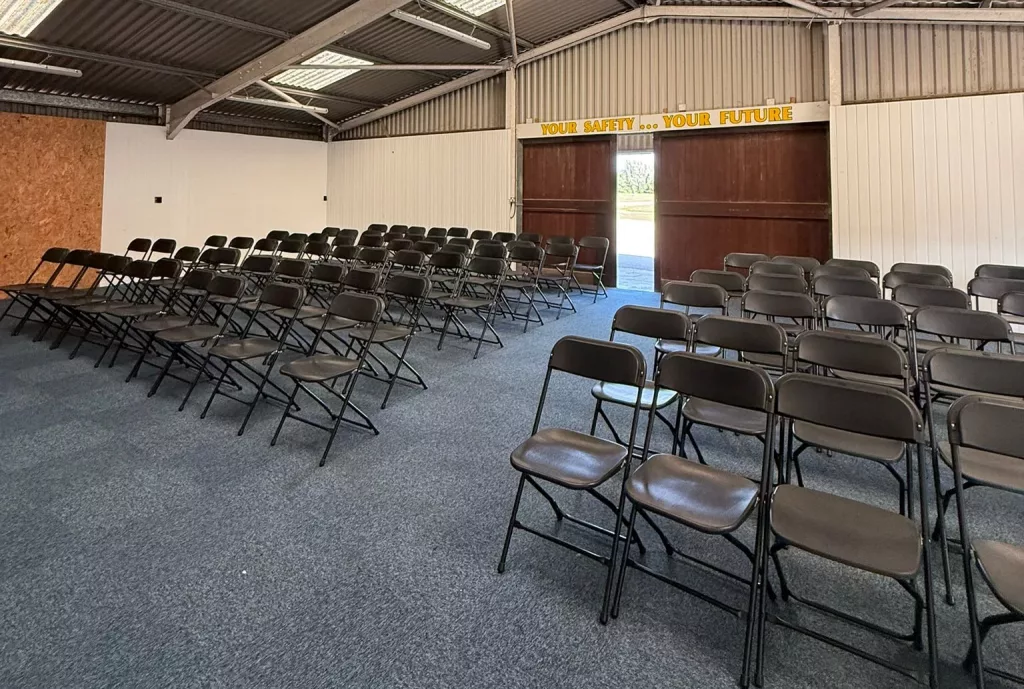 Black samsonite folding chairs in a row inside a converted barn